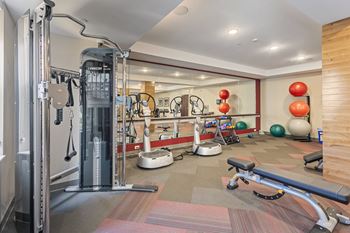 A gym with cardio equipment and weights on the floor